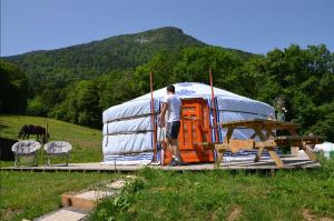 Un uomo è in piedi di fronte a una tenda di Yourtes Olachat proche Annecy a Faverges