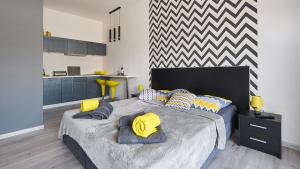 sypialnia z dużym łóżkiem z żółtymi i niebieskimi poduszkami w obiekcie Apartament Perła Pienin w mieście Dębno
