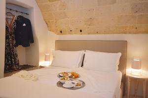 a white bed with a tray of food on it at I Bastioni San Domenico - Boutique Hotel in Gallipoli