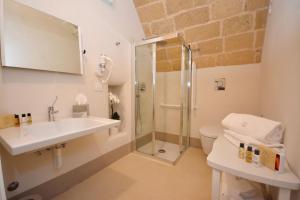 a bathroom with a shower and a sink and a toilet at I Bastioni San Domenico - Boutique Hotel in Gallipoli