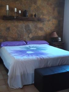 a bedroom with a bed and a stone wall at Casa El Horno in Antigua