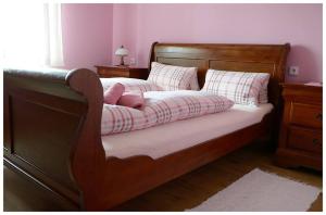Schlafzimmer mit einem Bett mit einem Holzrahmen und Kissen in der Unterkunft Penzion a Restaurace U Mámy in Frýdek-Místek