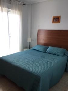ラ・マンガ・デル・マール・メノールにあるPUERTO MAR. PISCINA CON JACUZZIのベッドルーム1室(大型ベッド1台、木製ヘッドボード付)
