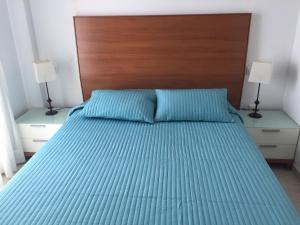 ラ・マンガ・デル・マール・メノールにあるPUERTO MAR. PISCINA CON JACUZZIのベッドルーム1室(ベッド1台、木製ヘッドボード、ランプ2つ付)