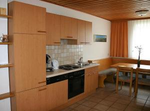 eine Küche mit Holzschränken und einem Herd mit Backofen in der Unterkunft Gästehaus Fischbach in Jois