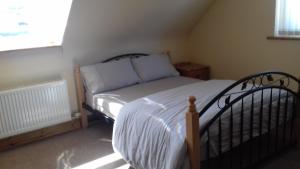 um pequeno quarto com uma cama num quarto em Teach Nellie Cottage em Loughanure