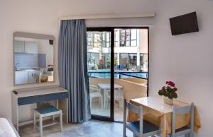 a small apartment with a table and a dining room at Akasti Hotel in Kalamaki