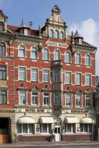 un grande edificio in mattoni rossi con un cartello con la richiesta dell'hotel di Hotel Ross a Meißen