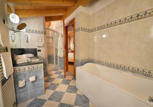 a bathroom with a tub, toilet, sink and bathtub at Hotel Posta in Livigno