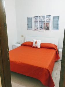 a bedroom with a bed with an orange bedspread at Appartamento Fronte Mare in Santa Teresa Gallura