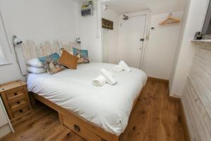 een slaapkamer met een wit bed en handdoeken bij Brunswick Garden Studio - Patio - by Brighton Holiday Lets in Brighton & Hove