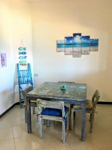 サンタ・テレーザ・ガッルーラにあるAppartamento Fronte Mareのダイニングテーブル(椅子付)、壁画