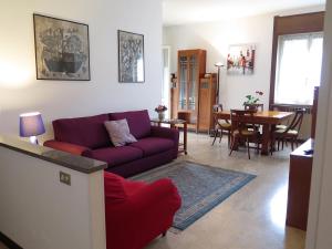 ein Wohnzimmer mit einem roten Sofa und einem Esszimmer in der Unterkunft Sveva in Stresa