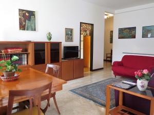 ein Wohnzimmer mit einem Tisch und einem roten Sofa in der Unterkunft Sveva in Stresa