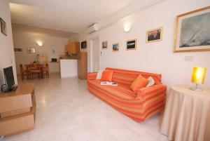 a living room with a couch and a table at Appartamenti Serenity - 2 posti auto - in villa e in centro in Marina di Campo