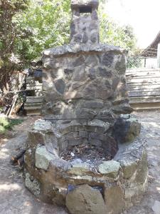 un viejo horno de piedra está sentado en un patio en St. Kristóf Vendégház, en Abádszalók