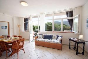a living room with a couch and a table at Appartamenti Serenity - 2 posti auto - in villa e in centro in Marina di Campo