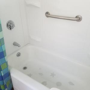 a bathroom with a bath tub with a shower at The becket Motel in Becket Center +27 photos