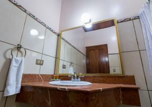 baño con lavabo y espejo grande en Hotel Manuel Antonio, en Manuel Antonio