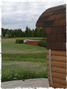 una escultura de un edificio con un campo en el fondo en Willa Mustijoki en Laukkoski