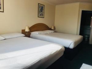 a hotel room with two beds and two lamps at Days Inn Watford Gap in Crick