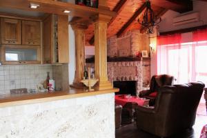 a kitchen with a counter and two chairs and a fireplace at Apartment Stanisic in Budva +24 photos