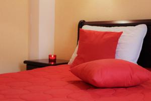 a red pillow sitting on top of a bed at Apartment Stanisic in Budva