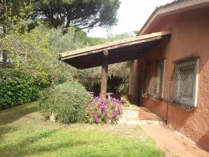 a porch of a house with a bunch of flowers at villetta nel verde vicino spiaggia in Orbetello