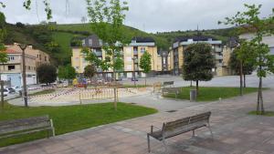 a park with benches and buildings in a city at APARTAMENTO EN URBANIZACION con PISCINA CENTRO DE UNQUERA-VAL DE SAN VICENTE IDEAL PAREJAS in Unquera