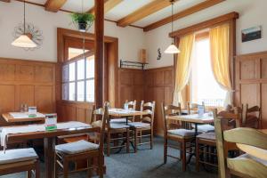 リギ・カルトバートにあるホテル レストラン アルピナの木製のテーブルと椅子のあるダイニングルーム