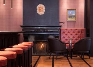 a bar with chairs and a fireplace in a room at Grand Hotel Zermatterhof in Zermatt