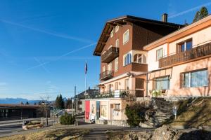 リギ・カルトバートにあるホテル レストラン アルピナの側面に旗が掲げられた建物