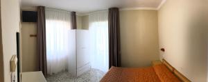 1 dormitorio con cama y espejo en Hotel Sirena, en Castellabate