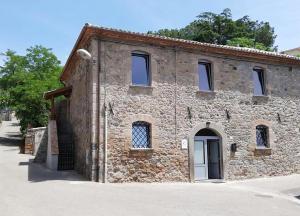 a stone building with a white door on a street at Casale 1541 in Bolsena