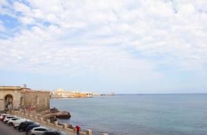 a row of cars parked next to a body of water at Sea Windows Suite in Trapani