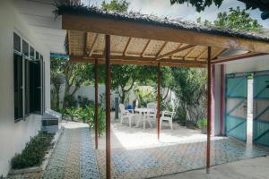 a pavilion with a table and chairs on a patio at Azoush Tourist Guesthouse in Fulhadhoo