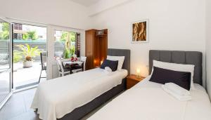 two beds in a room with a balcony at Apartments Medora in Rovinj +114 photos