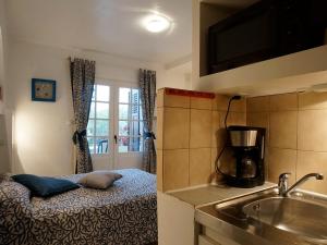 a kitchen with a sink and a coffee maker at Résidence Les Mandariniers in Hyères