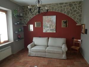 una sala de estar con un sofá contra una pared roja en L'Angolo di Dany, en Pianello