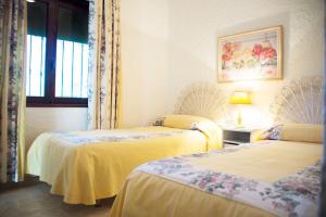 マルベーリャにあるCasa Sasのベッド2台と窓が備わる客室です。
