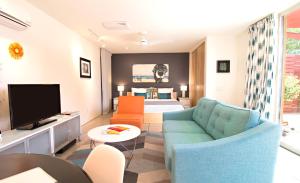 a living room with a couch and a television at Modern Casita in Historic Downtown Albuquerque in Albuquerque
