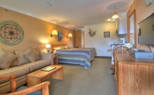 Sea Mist Resort Motel في ويلز: غرفة معيشة مع أريكة وسرير في غرفة