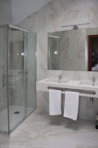 a bathroom with a shower and a sink with towels at Hotel Areces in Grado +18 photos