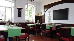 a restaurant with green tables and chairs and a flat screen tv at Hotel Restaurant Erbprinz Walldorf in Walldorf