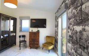 モンティセロにあるHotel Mineraの壁に椅子とテレビが備わる客室です。
