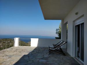 a chair sitting on the balcony of a house at Villa Karla in Pefkali