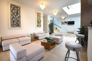 ein Wohnzimmer mit weißen Möbeln und einem Dachfenster in der Unterkunft Hotel Ristorante Il Vascello in Costa Rei