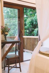 a room with a bed and a table and a window at Casa Crescente in Trancoso