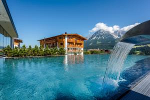 una piscina con una fuente de agua frente a un edificio en Hotel Der Bär, en Ellmau