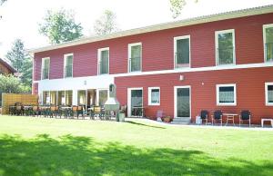 um edifício vermelho com mesas e cadeiras em frente em Rote Villa Füssen em Füssen